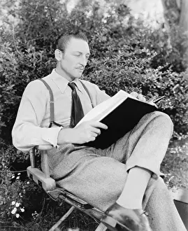 Casually: Man sitting in his garden reading a book