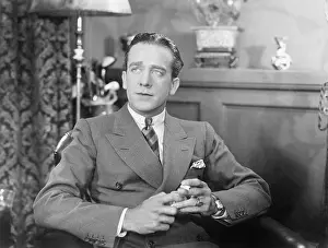 Headshots: Man sitting and holding a cigarette