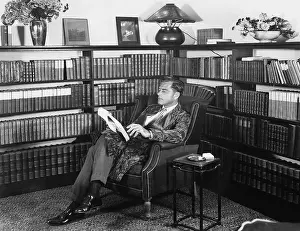 Calmness: Man sitting in his library reading a book