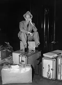 Fedora: Man sitting with luggage