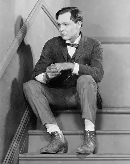 Lamenting: Man sitting on stairs looking anxious