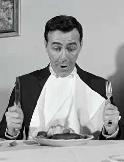 Dinnertime: Man sitting at table ready to eat dinner with