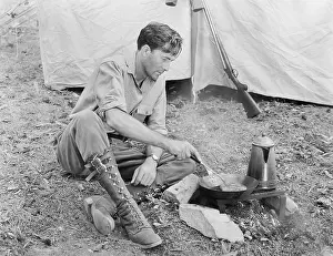 Roughing: Man sitting in front of his tent preparing food