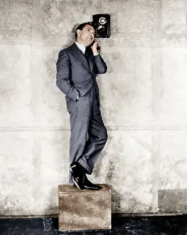Warranties: Man standing on a box to reach the telephone