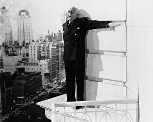 Chances: Man standing on the ledge of a building and looking feared
