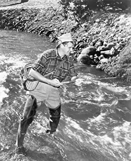 Waders: Man standing in a stream of water fishing