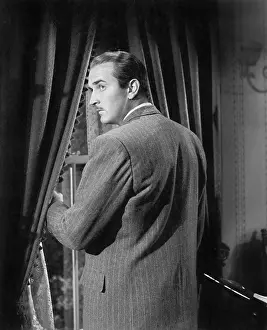 Mustaches: Man standing next to a window looking over his shoulder