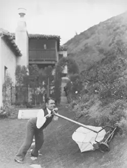 Mowing: Man struggling to mow lawn