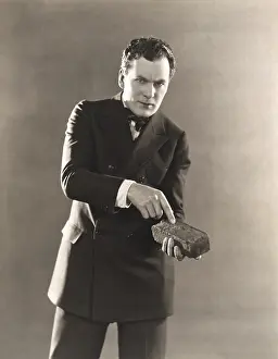 Ov1607: Man in suit holding a brick