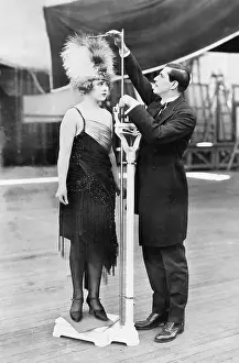 Embarrassment: Man taking a measurement of a woman with an oversized hat