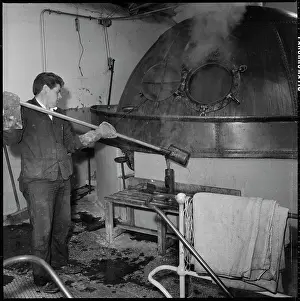 Mcmullens: A man taking a sample from a copper boiling kettle