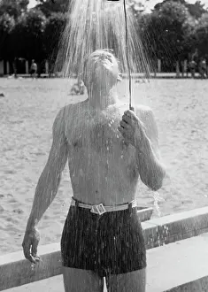 Showering: Man taking shower on beach