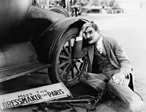 Stressing: Man trying to fix broken car