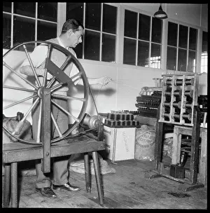 Deste: A man using a hand operated silk doubling wheel