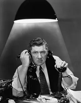 Stress: Man using two telephones