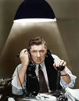 Stress: Man using two telephones