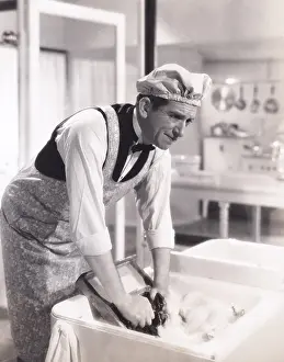 Suds: Man washing clothes in the kitchen sink