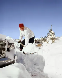 Laborious: Man Wearing Red Cap Digging out His Car Shoveling