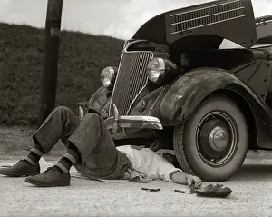 Fender: Man on back wearing striped socks fixing car