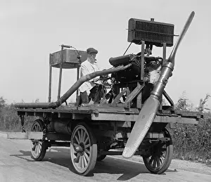 1 Person: Man on wheeled vehicle with mounted propeller, in