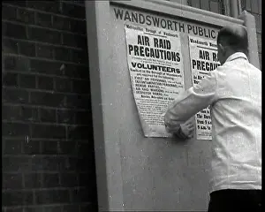 Wandsworth: A Man in a White Jacket Putting up Air Raid