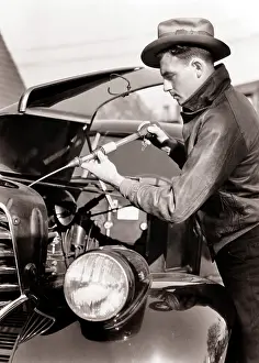 Hydrometer: Man Winterizing Automobile Engine with Hydrometer