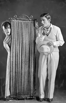 Peeking: Man with woman changing behind screen