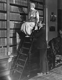 Rejection: Man with woman on ladder in library