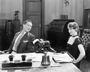 Businesspeople: Man and woman in an office flirting with each other