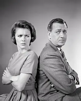 Irate: Man and Woman Sitting Back to Back Looking Over
