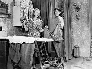 Marital: Man and woman standing in a kitchen while she is