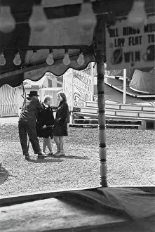 Hoopla: Man and two women at a closed fairground