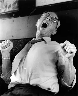 Fists: Man yawning and stretching on a train