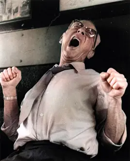 Fists: Man yawning and stretching on a train
