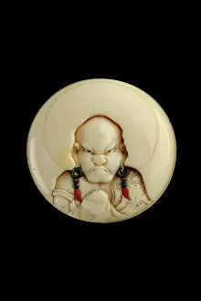 Netsuke: Manju netsuke with a head and shoulders portrait of a rakan