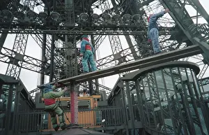 Symbolize: Mannequins of renovator workers on Eiffel Tower