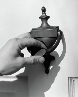 Knocker: Man's hand lifting door knocker