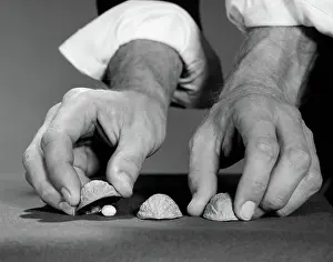 Sleight: Man's hands with shirt sleeves rolled up playing