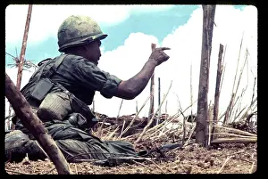 Quang: A Marine, under fire, points to an enemy position
