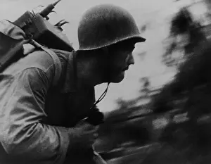 Lcgr1311: A Marine runs across the beach on Peleliu Island
