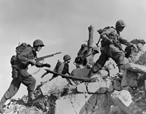 Offensives: Marines hurdle a stone wall as they arrive in