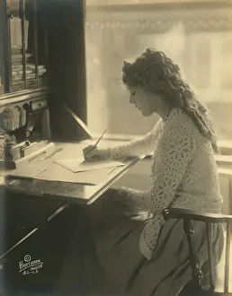 C1918: Mary Pickford writing at a desk