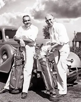 Fender: Two Mature Casually Dressed Men Leaning on Automobile