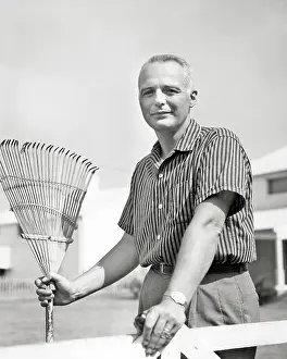 Yardwork: Mature Man Holding a Bamboo Rake