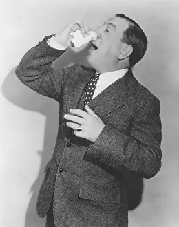 Ailment: Mature man in suit sneezing