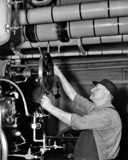 Regulating: Mature Man Worker Regulating Steam Pressure Or