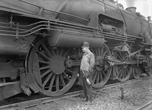 Large Scale: Mechanic servicing a railway steam engine in 1924