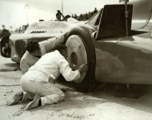 Nearside: Mechanics fitting hubcaps to Blue Bird