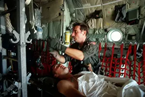 Intravenous: A medic adjusts the intravenous drip bag ?