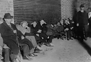 Major League: Men in business suits sit and sleep in line for